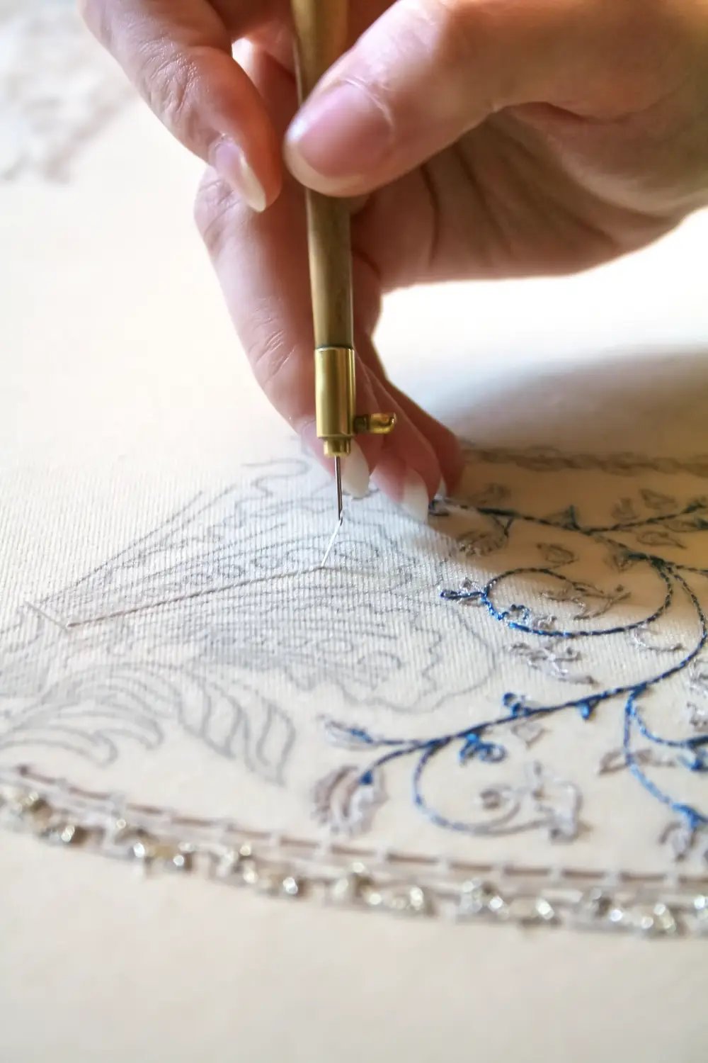 communication d'entreprise pour une artisane brodeuse. Photo sur la précision du geste et du fil accroché à l'aiguille. Photo de Luce Dupont pour Via Tara