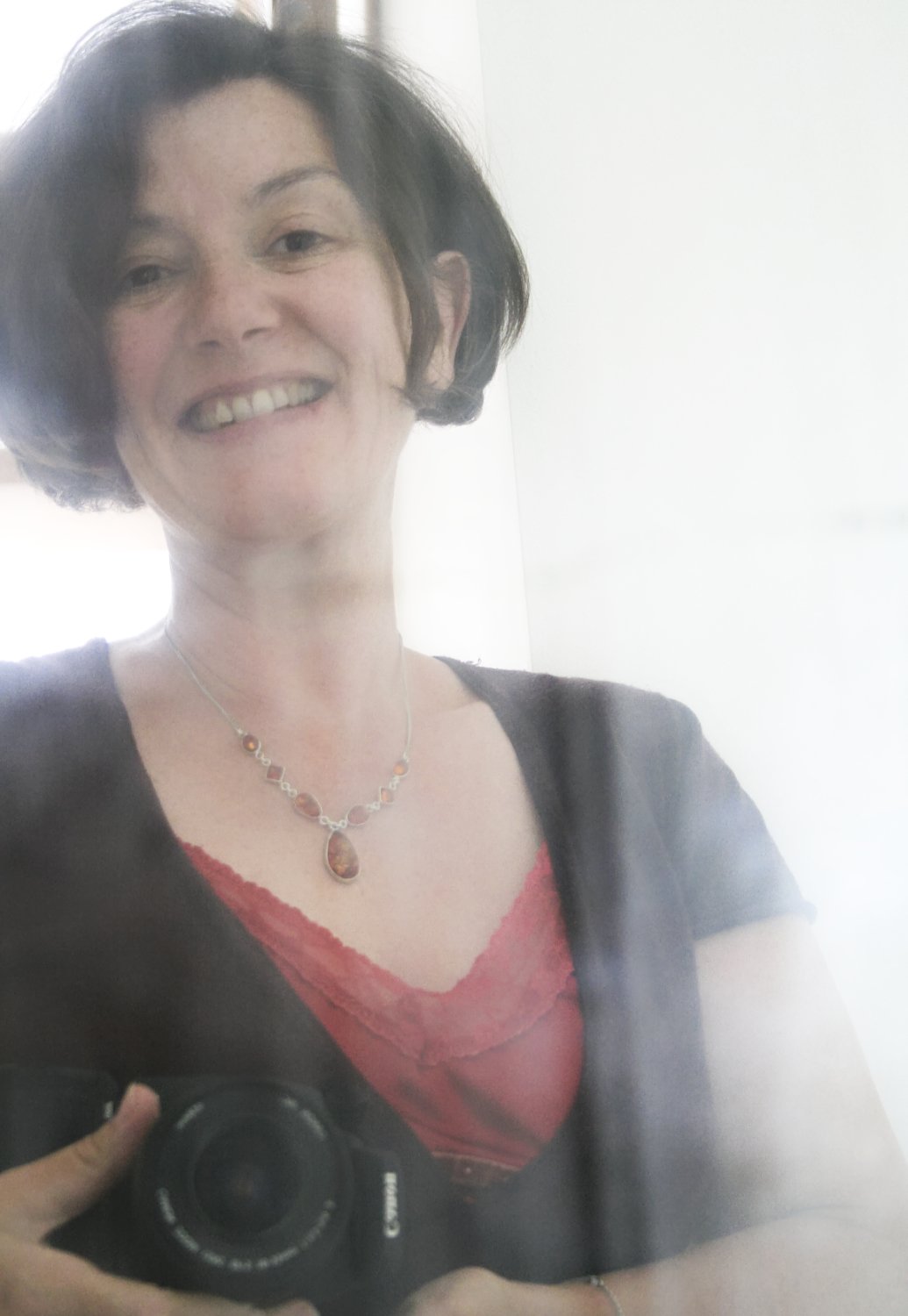 Autoportrait de Luce Dupont de Luce Dupont devant un miroir. Photographe des femmes, elle pose avac son appareil photo